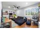 Spacious living room featuring a comfortable sofa, hardwood floors, ceiling fan, and bright window at 10098 Oaks Ln, Seminole, FL 33772