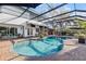 Inviting screened-in pool with brick patio, bar and ample seating at 10098 Oaks Ln, Seminole, FL 33772