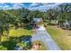 Beautiful aerial view of a home with a large yard surrounded by lush greenery and a long driveway at 11545 Kent Grove Dr, Spring Hill, FL 34610