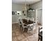 Elegant dining room featuring a dark wood table, white chairs, and a decorative chandelier at 11545 Kent Grove Dr, Spring Hill, FL 34610