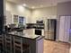 Modern kitchen with stainless steel appliances, black countertops, and white cabinets at 11545 Kent Grove Dr, Spring Hill, FL 34610