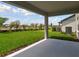 View from the covered lanai of the well-manicured lawn and landscaping of the backyard at 1158 Kistna Dr, Zephyrhills, FL 33540