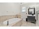 Spacious bathroom with a soaking tub, updated vanity, and modern fixtures and tiling at 1211 E Giddens Ave, Tampa, FL 33603