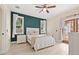 Stylish bedroom featuring an accent wall, a white bed with cozy bedding, and natural light from the windows at 1211 E Giddens Ave, Tampa, FL 33603