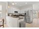 Modern kitchen featuring stainless steel appliances, white cabinetry, and a breakfast bar for casual dining at 1211 E Giddens Ave, Tampa, FL 33603