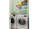 Efficient laundry space with modern washer, dryer, and convenient storage rack system at 1211 E Giddens Ave, Tampa, FL 33603