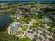 This aerial shows a community with a golf course, lake, tennis, and pool at 12141 Arron Ter, Trinity, FL 34655