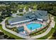 Aerial view of the community clubhouse with a pool, lush landscaping, and outdoor seating at 12141 Arron Ter, Trinity, FL 34655