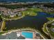 Panoramic aerial of community with a pool, golf course, water features, and residential area at 12141 Arron Ter, Trinity, FL 34655