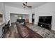 Bright living room with wood floors, a ceiling fan, and sliding doors to the screened lanai at 12141 Arron Ter, Trinity, FL 34655