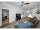 Comfortable living room with wood floors, a ceiling fan, and an arched doorway to a bedroom at 12141 Arron Ter, Trinity, FL 34655