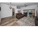 Spacious living room with wood floors, an archway to the kitchen, and a view of the screened lanai at 12141 Arron Ter, Trinity, FL 34655