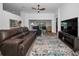 Inviting living room showcasing wood floors, a ceiling fan, and access to the screened lanai overlooking a lake at 12141 Arron Ter, Trinity, FL 34655