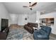 Open living room with wood floors, ceiling fan, and a view into the kitchen with bar seating at 12141 Arron Ter, Trinity, FL 34655