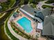 Aerial view of community pool with ample seating, a hot tub, and lush landscaping near a waterway at 12141 Arron Ter, Trinity, FL 34655