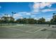 Well-maintained tennis court features a smooth surface, net, and tall lighting for evening play at 12141 Arron Ter, Trinity, FL 34655