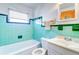 Bathroom with teal tile, white vanity, and bathtub at 1235 45Th N St, St Petersburg, FL 33713