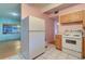 White appliances and wood cabinets in this retro kitchen at 1235 45Th N St, St Petersburg, FL 33713