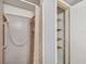 Bathroom featuring a shower with blue tile and a shelved linen closet at 14005 Leeward Dr, Seminole, FL 33776