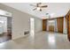 Spacious living room featuring ceiling fans, wood paneling and a view into the laundry room at 14005 Leeward Dr, Seminole, FL 33776