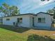 Back exterior view of the home, showcasing the lawn and a door to the backyard at 1436 Rose St, Clearwater, FL 33756