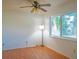 Cozy bedroom featuring a ceiling fan, hardwood floors, and a large window at 1436 Rose St, Clearwater, FL 33756