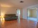 Living room with wood-look floors, neutral walls, and comfortable dark-gray reclining sofa at 1436 Rose St, Clearwater, FL 33756