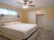 Main bedroom featuring carpeted floors and a decorative headboard, and sliding closet doors at 1436 Rose St, Clearwater, FL 33756