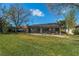 Lush backyard featuring a screened-in lanai, green lawn, and mature trees against a sunny backdrop at 1509 Ventana Dr, Sun City Center, FL 33573