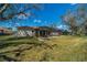 Expansive backyard showing a screened lanai, lush lawn, and mature trees on a sunny day at 1509 Ventana Dr, Sun City Center, FL 33573