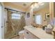 Bathroom featuring a walk-in shower with glass door, vanity with marble countertop, and warm lighting at 1509 Ventana Dr, Sun City Center, FL 33573