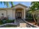 Inviting front entrance with double doors, a stone pathway, and colorful landscaping at 1509 Ventana Dr, Sun City Center, FL 33573