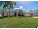 Attractive single-story home with lush green lawn, palm trees, and a two-car garage at 1509 Ventana Dr, Sun City Center, FL 33573