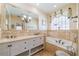 Elegant main bathroom with double vanity, soaking tub, and natural lighting at 1509 Ventana Dr, Sun City Center, FL 33573