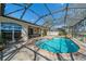 Beautiful screened pool area with brick pavers, mature plants, and outdoor seating; exterior view at 1509 Ventana Dr, Sun City Center, FL 33573