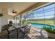 Inviting screened patio featuring a dining set, ceiling fan, and views of the pool and backyard at 1509 Ventana Dr, Sun City Center, FL 33573