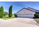 Three-car garage with white doors and landscaping at 18531 Lithia Ranch Rd, Lithia, FL 33547