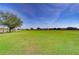 Open grassy lot with wooden fence and distant homes at 18531 Lithia Ranch Rd, Lithia, FL 33547