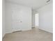 Bright bedroom with light wood floors, white walls and door, and minimalist design at 2604 Knight Island Dr, Brandon, FL 33511