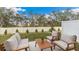 Back patio seating area with a well-maintained lawn and a white fence with an abundance of trees as a backdrop at 2744 Newbern Banks Dr, Bradenton, FL 34208