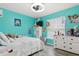 Cozy bedroom with bright turquoise walls, white furniture, and a ceiling fan at 2799 Wesleyan Dr, Palm Harbor, FL 34684