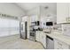 Well-lit kitchen showcasing stainless steel appliances, granite countertops, and tile floors with a breakfast bar at 2799 Wesleyan Dr, Palm Harbor, FL 34684