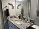 Bathroom with white vanity, granite countertops, turtle decor, and a decorative mirror at 3150 Mission Grove Dr # 3150, Palm Harbor, FL 34684