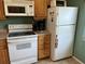 White appliances and wood cabinets in the kitchen at 3150 Mission Grove Dr # 3150, Palm Harbor, FL 34684