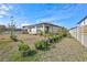 Backyard view of home with a row of potted plants next to the white fence at 3192 King Fern Dr, Wimauma, FL 33598