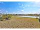 Expansive backyard view overlooking a large pond on a sunny day at 3192 King Fern Dr, Wimauma, FL 33598