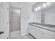 Modern bathroom featuring double sinks, granite countertops, white cabinetry, and a tiled shower stall at 3192 King Fern Dr, Wimauma, FL 33598