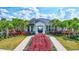 Elegant community clubhouse entrance with lush landscaping and tropical palm trees at 3192 King Fern Dr, Wimauma, FL 33598