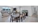 Dining room area boasting a large table with seating for eight, a modern chandelier, and large windows at 3192 King Fern Dr, Wimauma, FL 33598