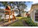 Backyard with a swing set and grass, a small storage shed, and some landscaping at 3203 W San Carlos St, Tampa, FL 33629